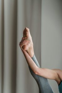 A dancer stretches their leg high.