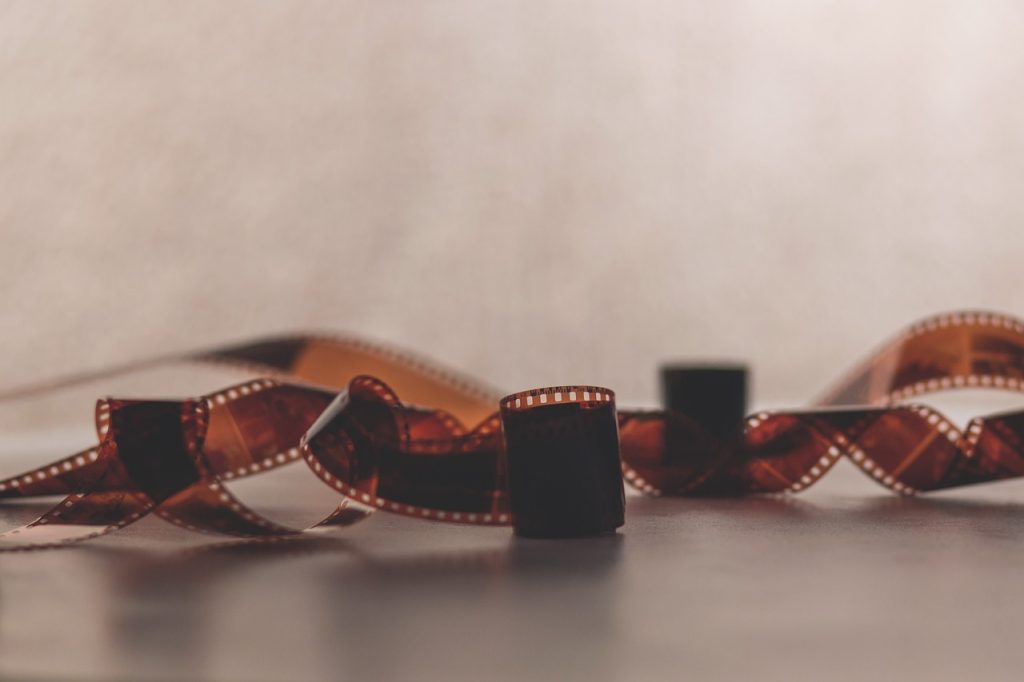 A roll of film spread across a table in sepia colours