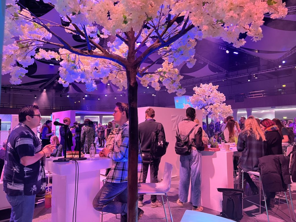 People discussing under an artifical cherry tree at the community hub in Digifest